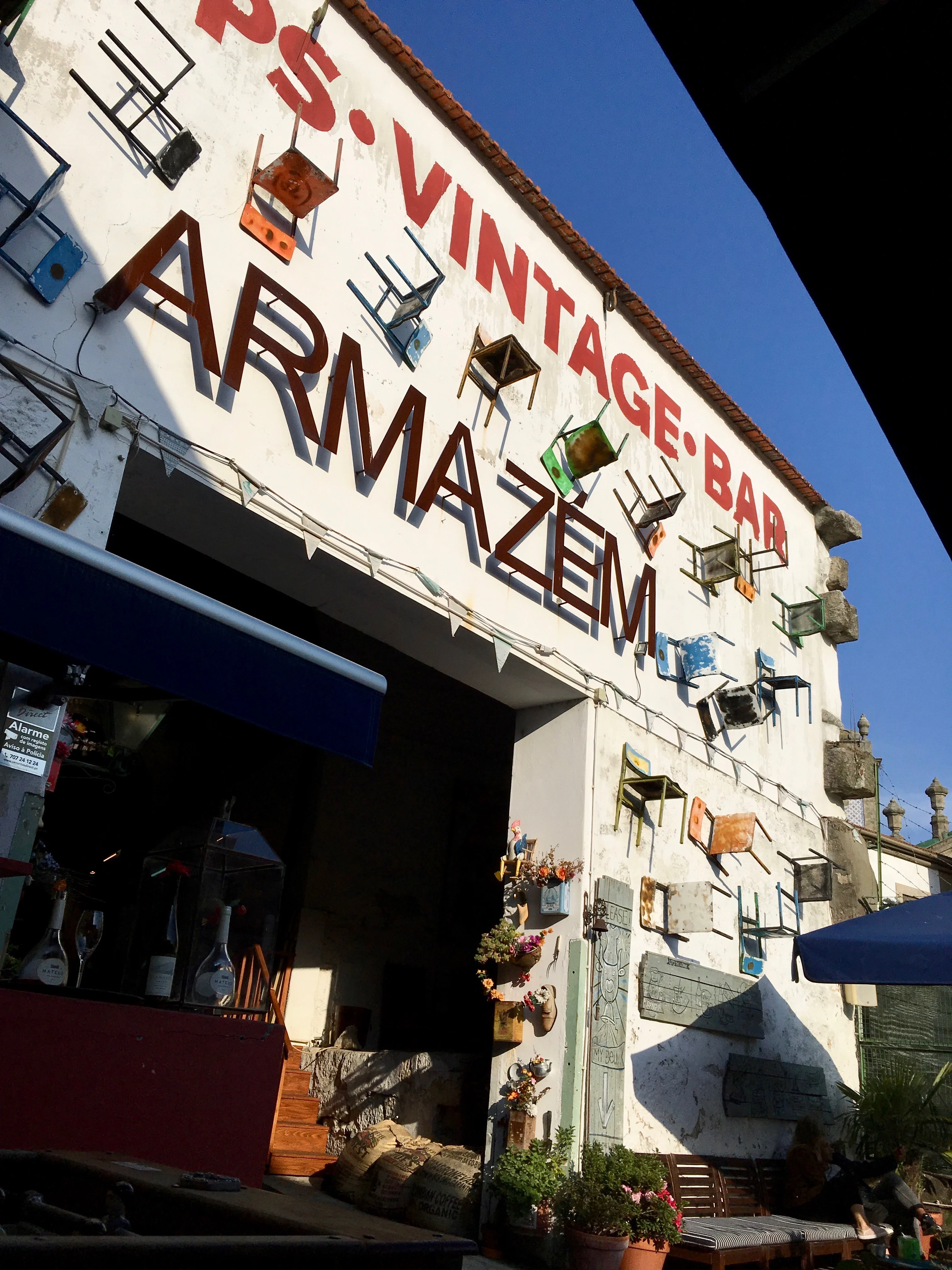 The facade of Armazém, decorated with floating, multicolored chairs 