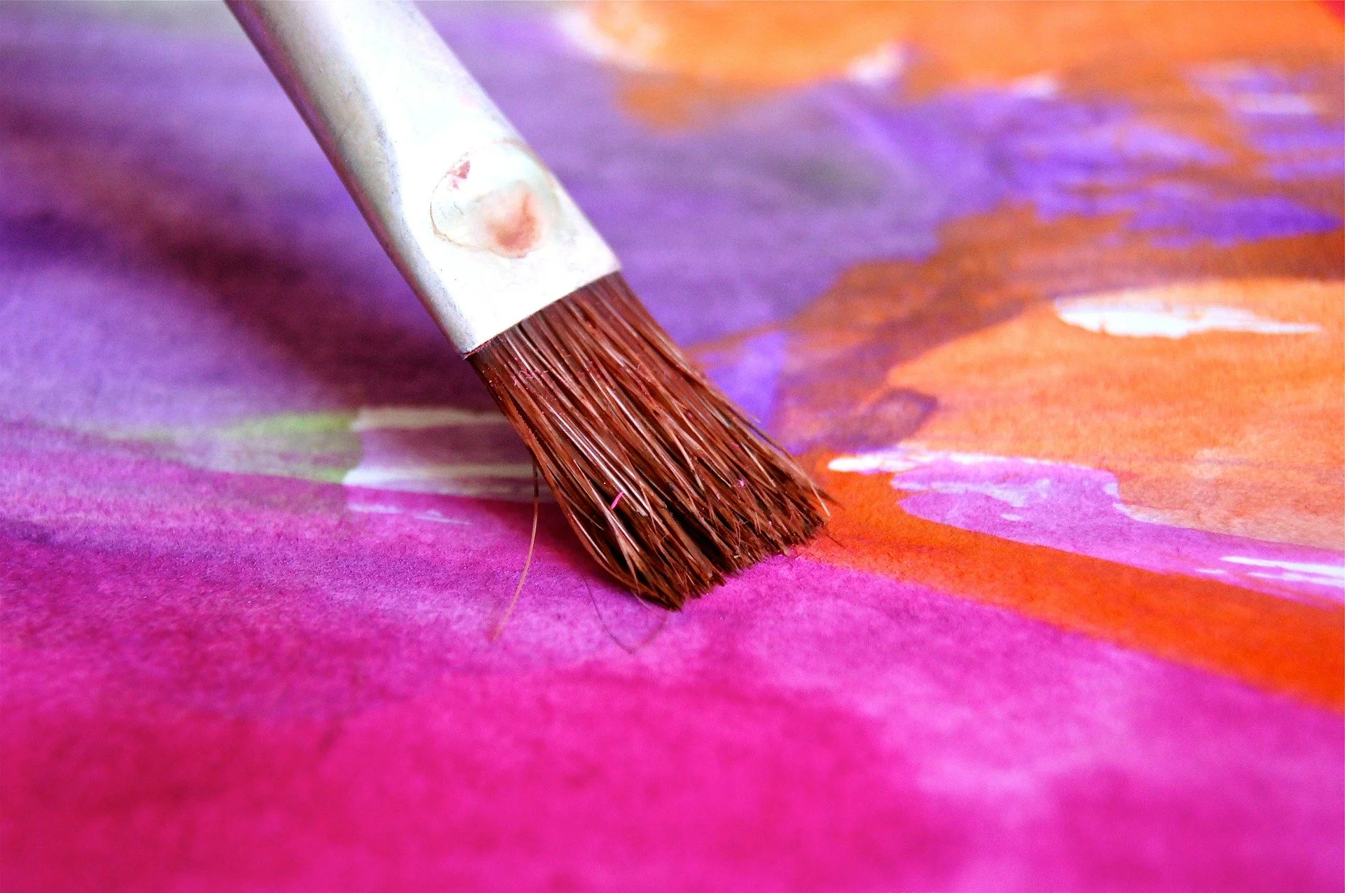 Paint brush on a colorful canvas