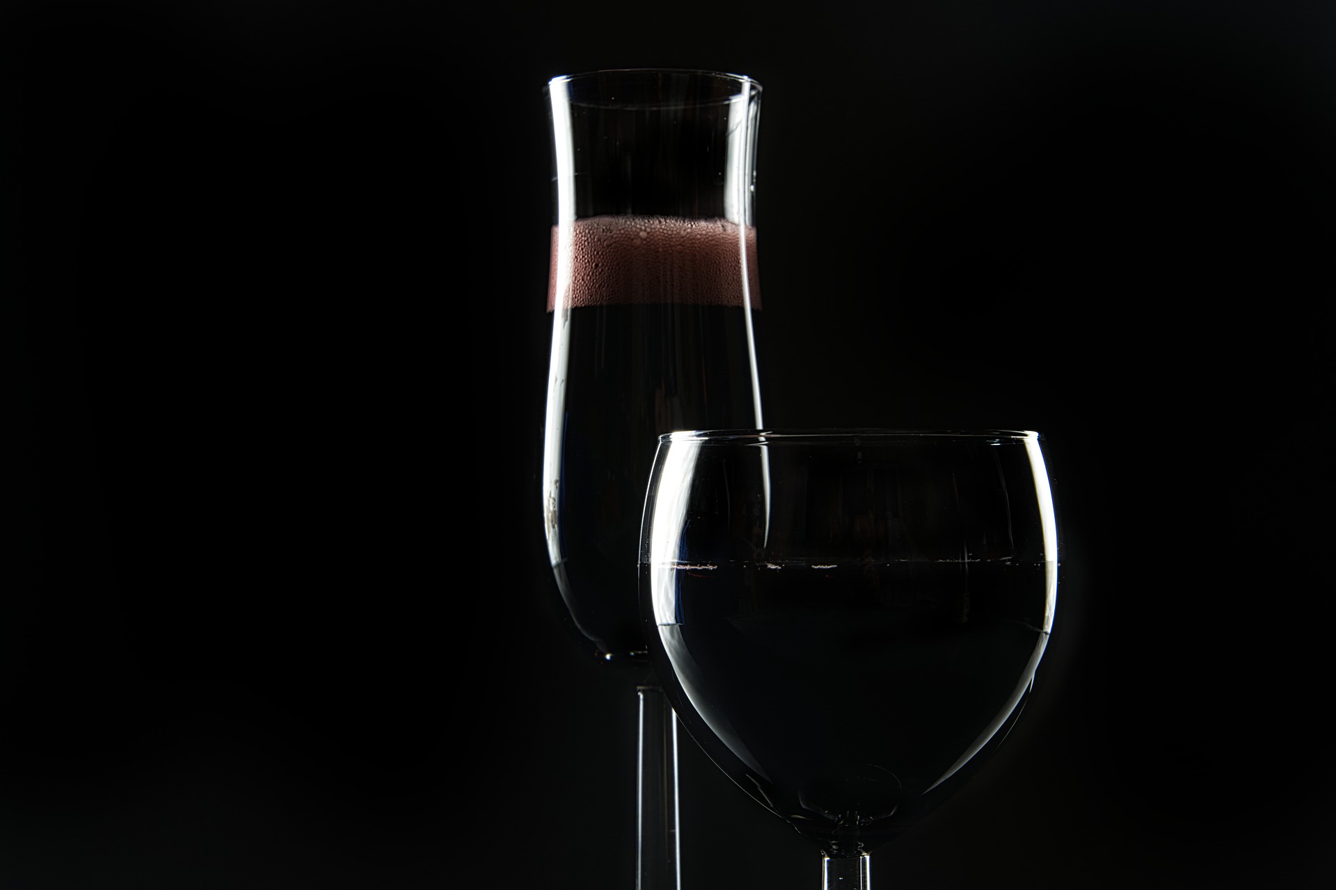 Two black cocktails against a black background