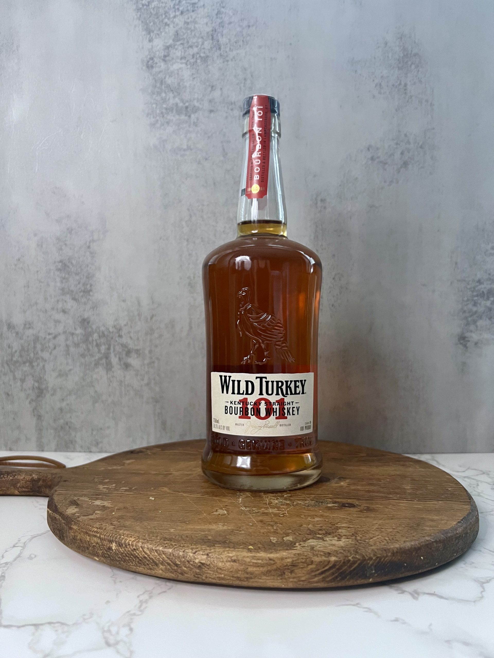 A bottle of Wild Turkey 101 bourbon on a countertop. 